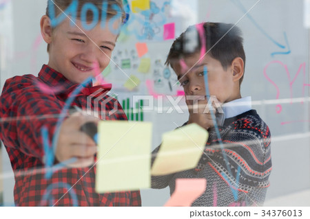 Kids as business executives discussing over whiteboard Kids as business executives discussing over whiteboard 34376013