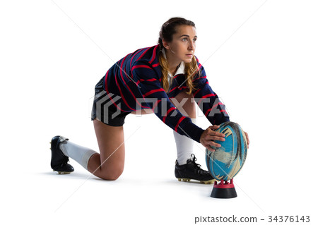 Full length of young female athlete keeping rugby ball on tee Full length of young female athlete keeping rugby ball on tee 34376143