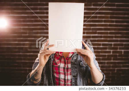 Woman hiding face from blank sheet Woman hiding face from blank sheet 34376233