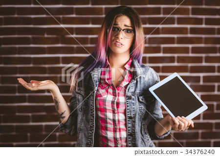 Portrait of confused woman holding digital tablet 34376240