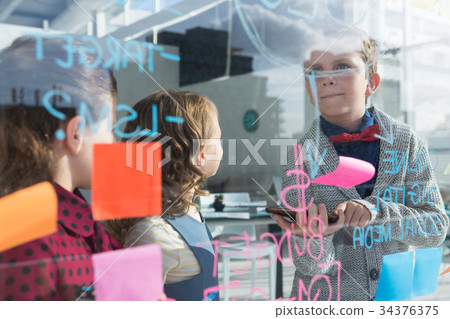 Business people analyzing data at office seen through glass Business people analyzing data at office seen through glass 34376375
