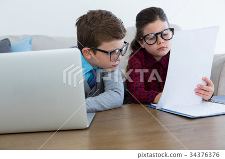 Business people discussing paperwork while sitting on sofa Business people discussing paperwork while sitting on sofa 34376376