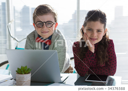 Portrait of smiling business people standing at table Portrait of smiling business people standing at table 34376388