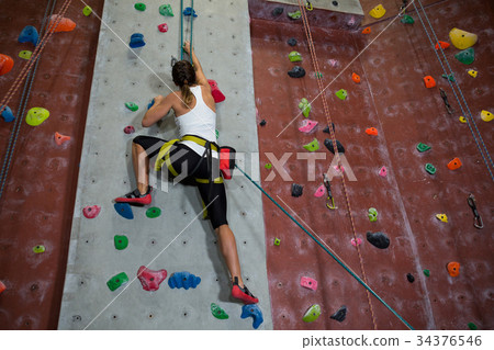 Woman practicing rock climbing in fitness studio 34376546