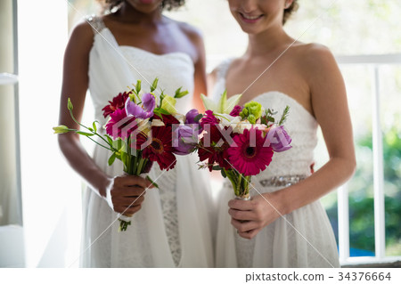 Bride and bridesmaids standing with bouquet 34376664