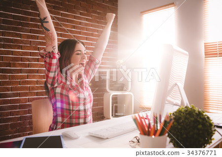 Excited executive using desktop computer in office Excited executive using desktop computer in office 34376771