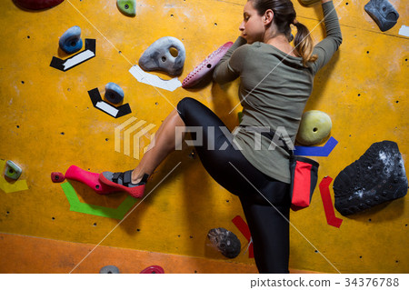 Determined woman practicing rock climbing Determined woman practicing rock climbing 34376788