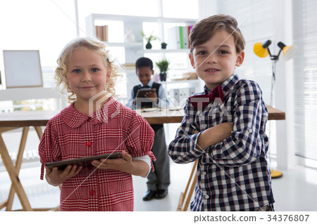 Portrait of confident colleagues with businessman in background at office 34376807