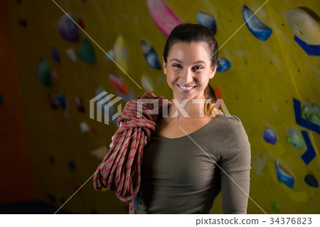Happy woman with rope in fitness studio 34376823