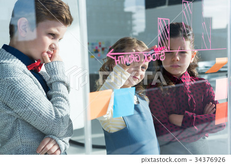 Colleagues planning while writing on window Colleagues planning while writing on window 34376926