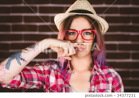 Beautiful woman pretending to have a fake moustache Beautiful woman pretending to have a fake moustache 34377231