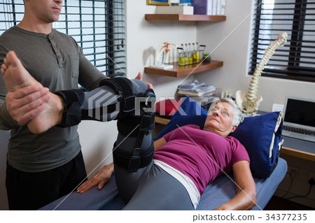 Male physiotherapist giving leg massage to patient 34377235