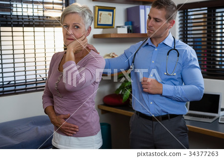 Physiotherapist examining a patient's neck 34377263
