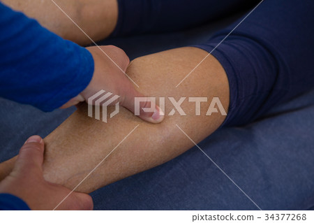 Physiotherapist giving leg massage to a woman 34377268