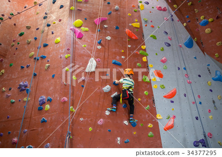 Boy practicing rock climbing in fitness studio 34377295