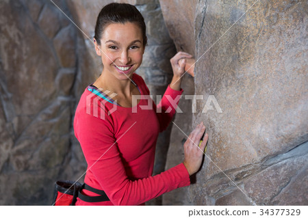 Portrait of confident woman practicing rock climbing Portrait of confident woman practicing rock climbing 34377329