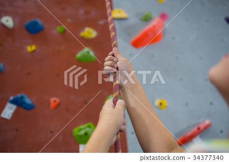 Boy practicing rope climbing in fitness studio 34377340