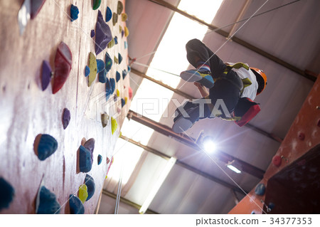 Determined boy practicing rock climbing 34377353