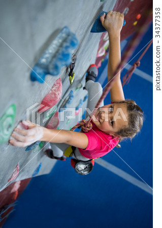 Portrait of teenage girl practicing rock climbing Portrait of teenage girl practicing rock climbing 34377358