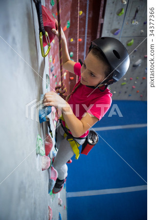 Determined teenage girl practicing rock climbing Determined teenage girl practicing rock climbing 34377366