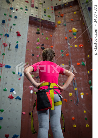 Rear view of teenage girl standing with hands on hip Rear view of teenage girl standing with hands on hip 34377372