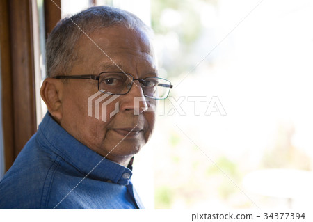 Portrait of serious senior man by window in nursing home 34377394