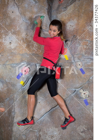 Portrait of confident woman practicing rock climbing Portrait of confident woman practicing rock climbing 34377426