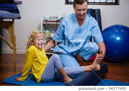 Physiotherapist giving physical therapy to the girl Physiotherapist giving physical therapy to the girl 34377495