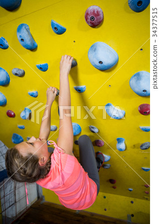 Teenage girl practicing rock climbing Teenage girl practicing rock climbing 34377515