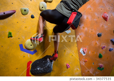 Low section of woman practicing rock climbing Low section of woman practicing rock climbing 34377535