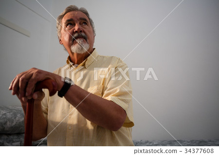 Thoughtful senior man standing outdoors during foggy weather Thoughtful senior man standing outdoors during foggy weather 34377608