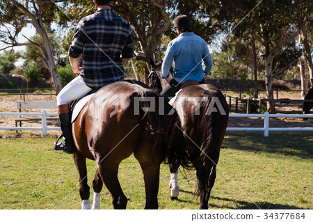 Two male friends riding horse in the ranch 34377684