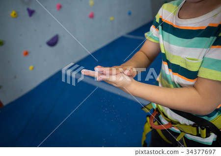 Boy rubbing powder on hands in studio 34377697