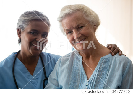 Portrait of smiling nurse and senior woman in nursing home 34377700