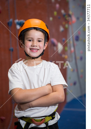 Boy standing with arms crossed in fitness studio Boy standing with arms crossed in fitness studio 34377711