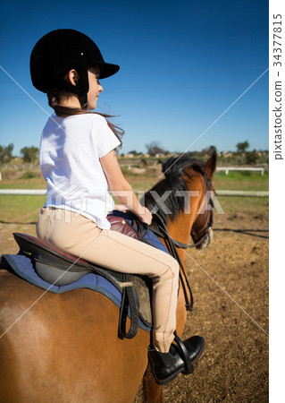 Girl riding a horse in the ranch Girl riding a horse in the ranch 34377815