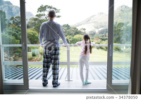 Father and daughter standing together in balcony Father and daughter standing together in balcony 34378050