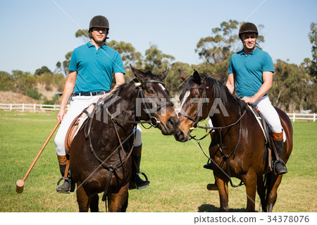 Two male jockeys riding horse in the ranch 34378076