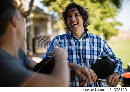 Two male friends interacting with each other in the ranch Two male friends interacting with each other in the ranch 34378113