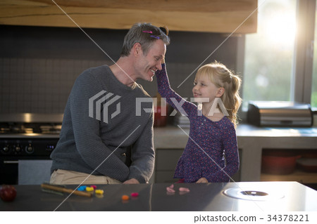 Daughter brushing fathers hair 34378221