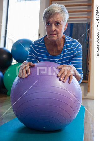 Senior woman in performing exercise on fitness ball 34378447