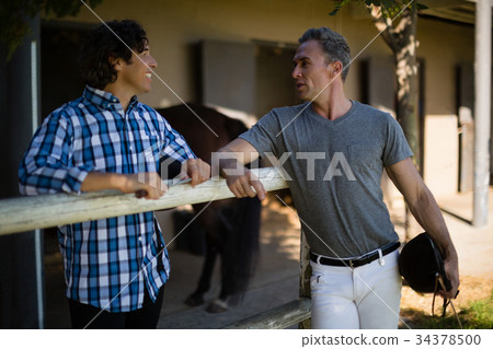 Two male friends interacting with each other in the ranch 34378500