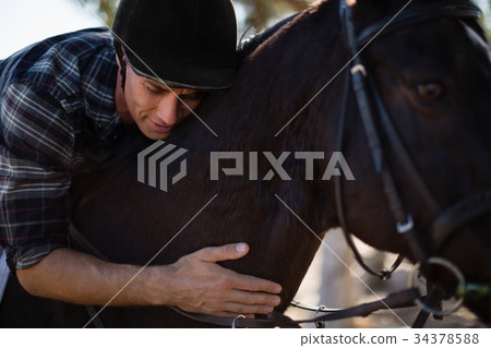 Male jockey riding horse in the ranch 34378588