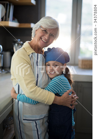Grandmother and granddaughter embracing in the kitchen 34378804