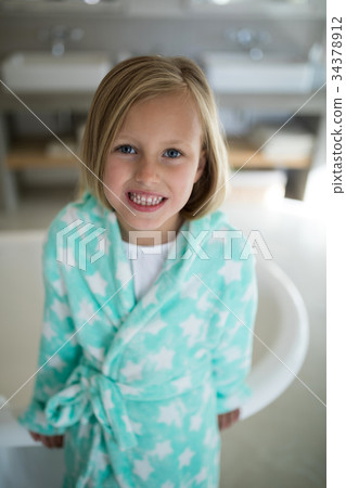 Smiling girl standing near bathtub in bathroom 34378912