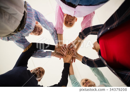 Directly below shot of happy senior friends stacking hands 34379208