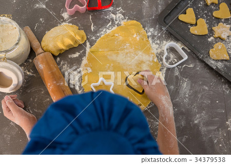 Cropped hands of boy preparing cookies in kitchen 34379538
