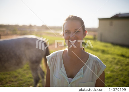 Portrait of jockey standing on field at barn 34379599