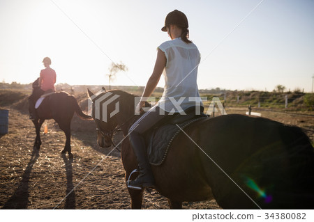 Female jockeys riding horse 34380082