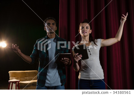 Actors rehearsing on stage while using digital tablet Actors rehearsing on stage while using digital tablet 34380561